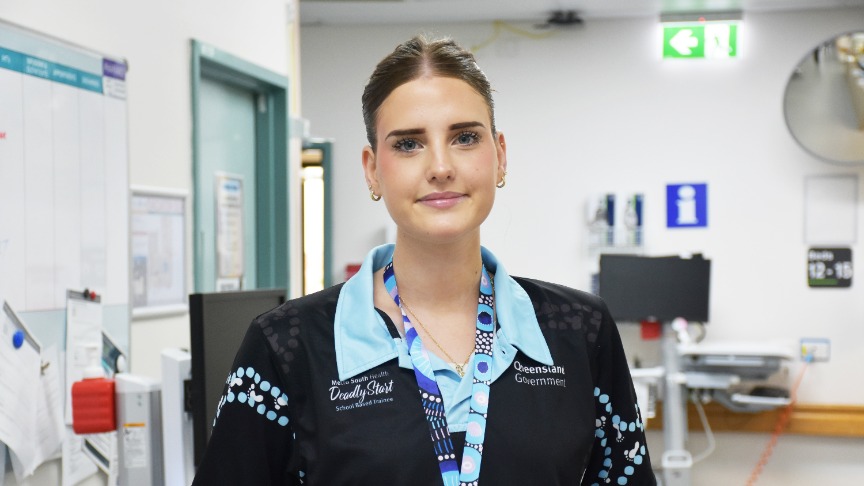 profile picture of a young woman with her hair in a ponytail standing in a hospital