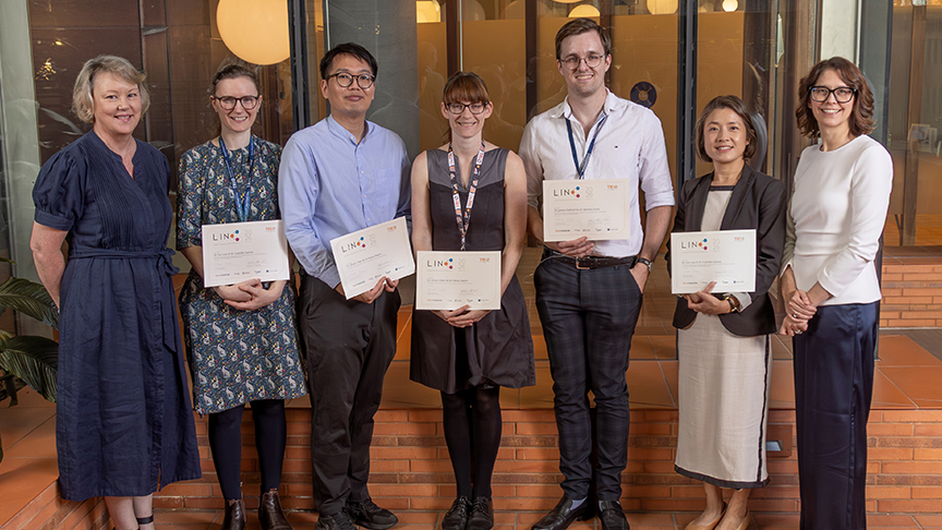 A group of staff holding up certificates
