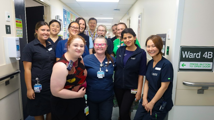 A group of health professionals standing in a hallway of a hospital