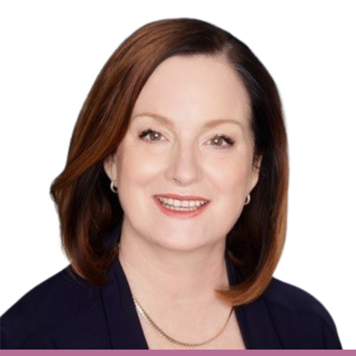 A person with shoulder length brown hair, and a navy blazer 