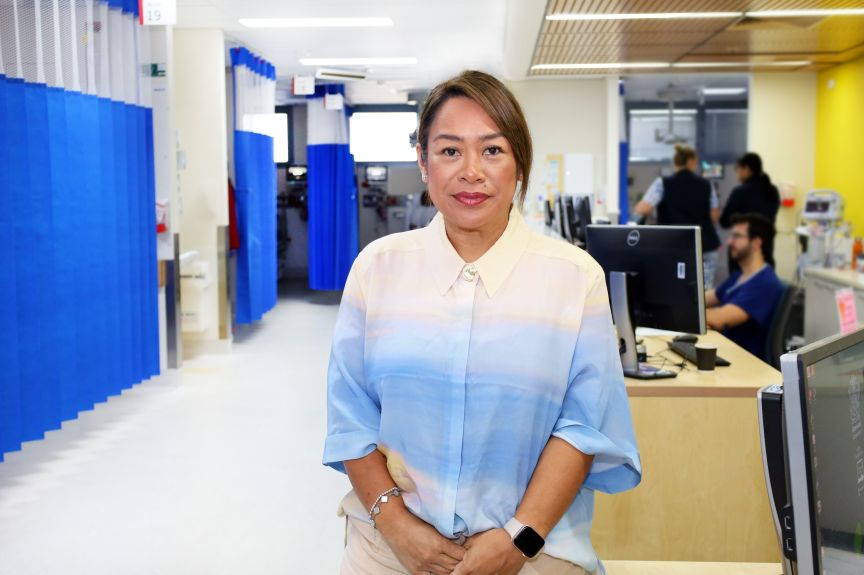 Nurse of the Year, Ange Cox, stands in front of a computer in the PA Hospital emergency department