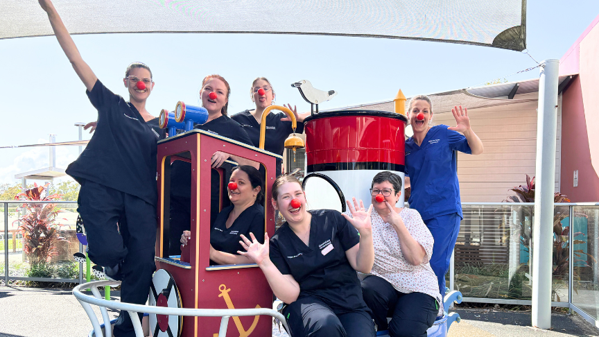 Group of nurses in playground wearing red noses