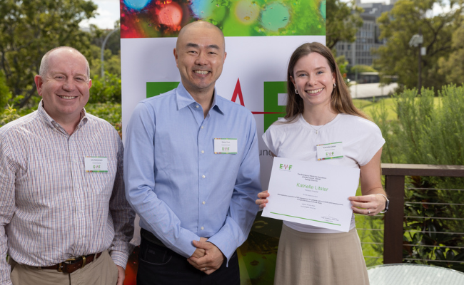 male and female staff members with award