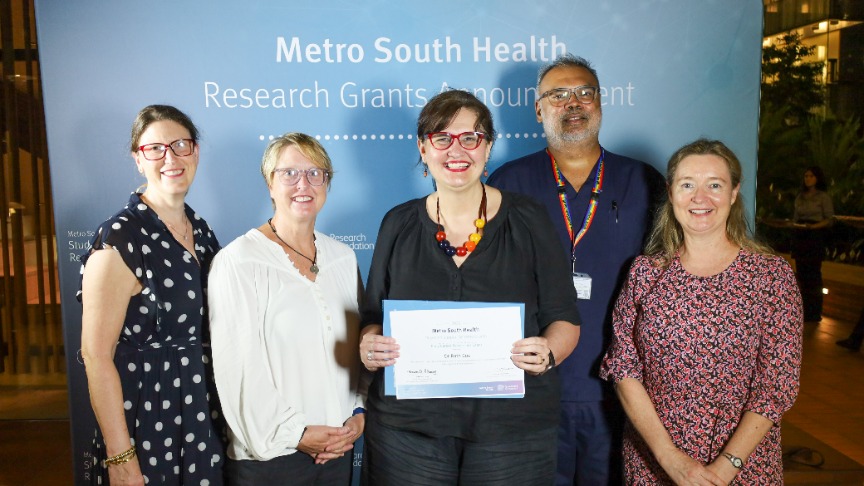 A group of researchers standing together receiving an award.